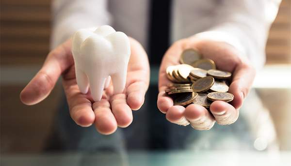 右手に歯の模型、左手に小銭を乗せ天秤にかけているようなイメージ。サージカルガイドに限らず治療内容や金額に納得してから進めることが大切
