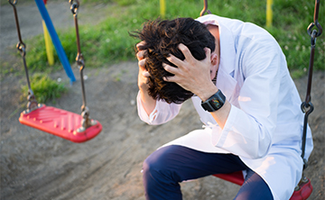 歯の神経の痛みにより頭痛がひどくなり頭を押さえている写真