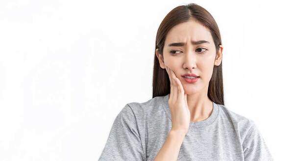 親知らずはいつ頃から生えるのか抜歯する必要があるのか悩んでいる女性の写真