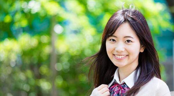 制服を着用した女性の写真。親知らずは18歳ころから生え始めます。